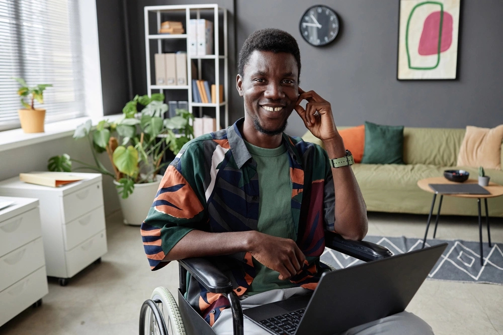 portrait of disabled men on wheelchair working on laptop from home