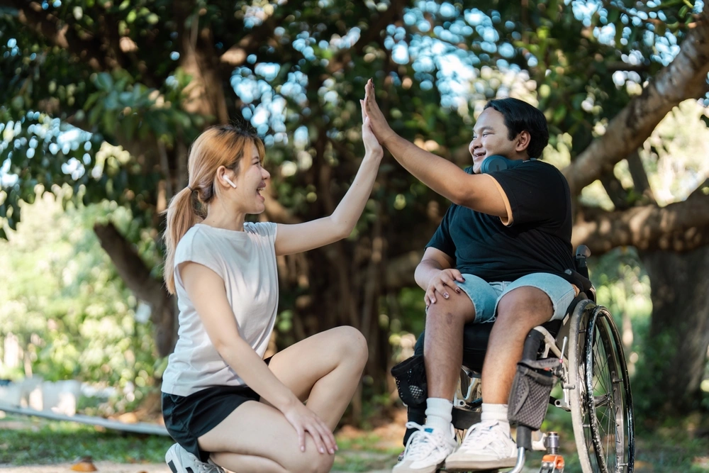 disabled person on wheelchair hanging out with carer in a park